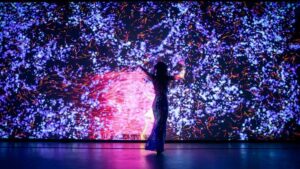 woman in a dress in front of a blue and pink cosmic light display
